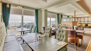 A hotel dining area with tables, chairs, and a view of the sea. - Premier Inn Isle of Wight Sandown - Seafront (Sandown)