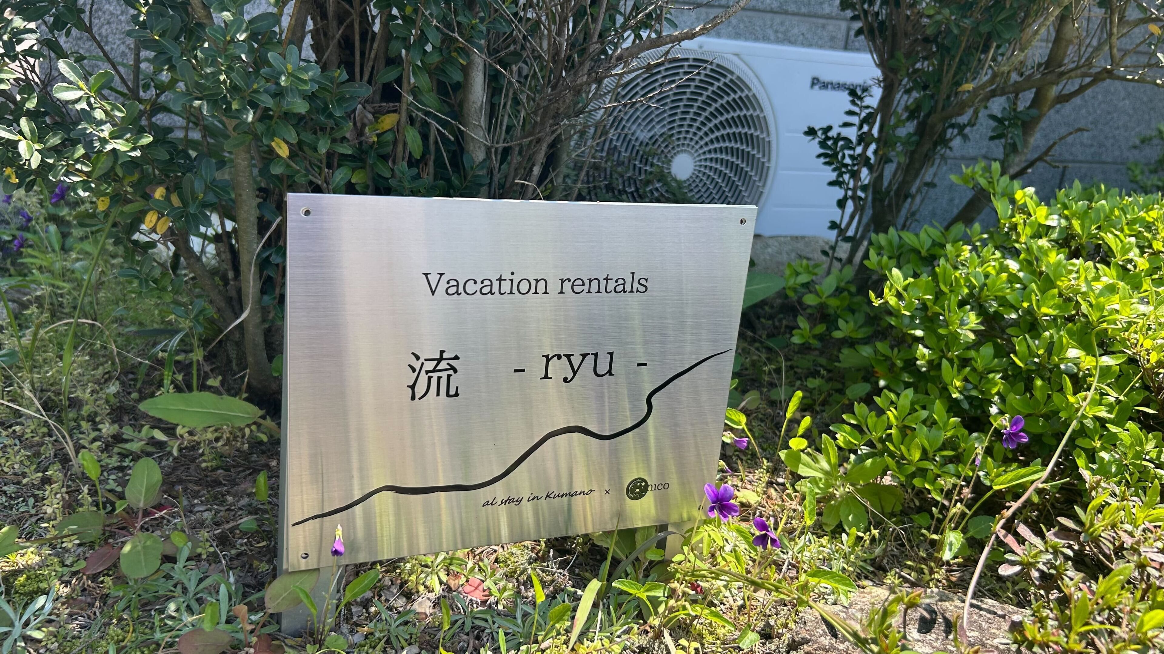 A sign for vacation rentals with Chinese characters and a logo.