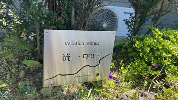 A sign for vacation rentals with Chinese characters and a logo.