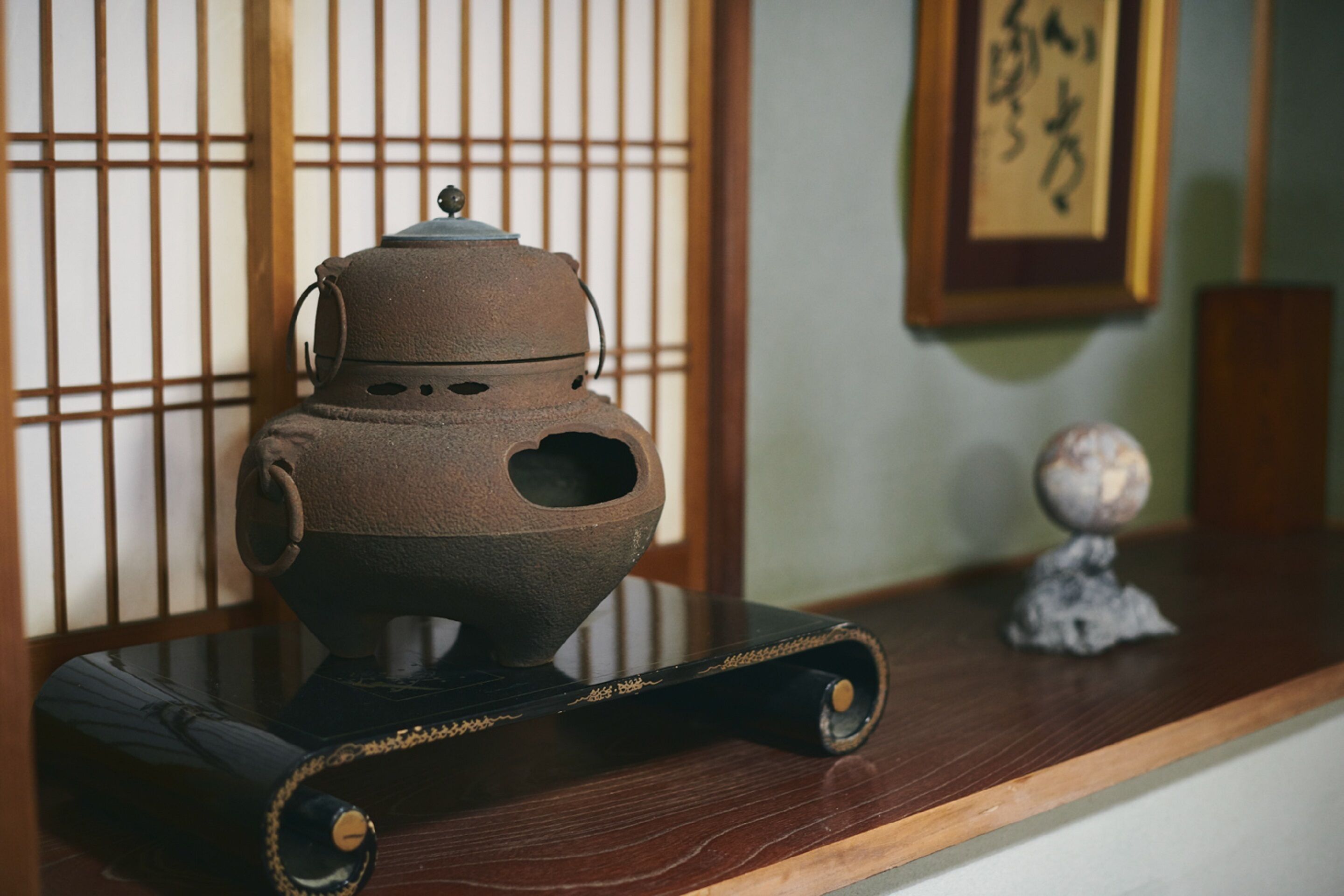 A traditional Japanese tea set on a wooden table with a sliding door in the background.
