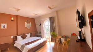 A bedroom with a bed, bedside table, and a small seating area with a table and chairs. - HANZ Chuong Hotel Da Lat (Xuan Huong - Da Lat)