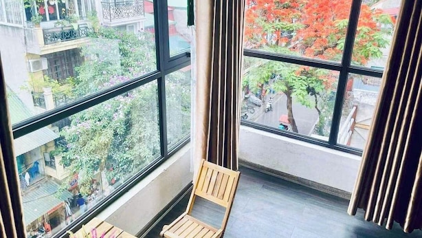 A room with large windows, a wooden chair, and a small table.