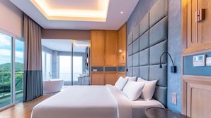 Habitación de hotel moderna con una cama grande, una mesita redonda de madera y vistas a un balcón.