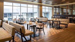 Un restaurante espacioso con techos altos, ventanas amplias y una decoración de diseño moderno.