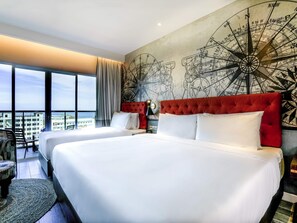 Habitación de hotel con dos camas, un ventanal con vistas y una pared con diseño de mapa.