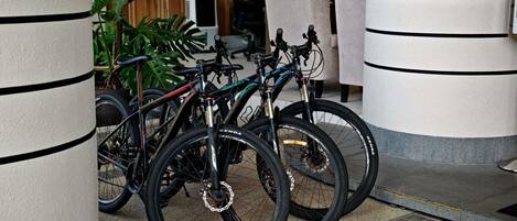 Un aparcamiento para bicicletas con bicicletas, un muro de madera y una zona de estar al fondo.