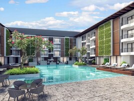 A modern hotel with a central swimming pool, outdoor seating, and vertical gardens on the building facades.