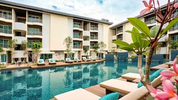 Relax by the pool surrounded by lounge chairs and comfortable cushions.