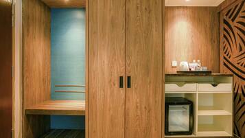 A modern room with a wooden wardrobe, a bench, a small refrigerator, and a decorative wall panel.