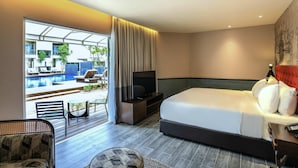 Habitación de hotel con cama, televisión y vistas a un área de piscina al aire libre.