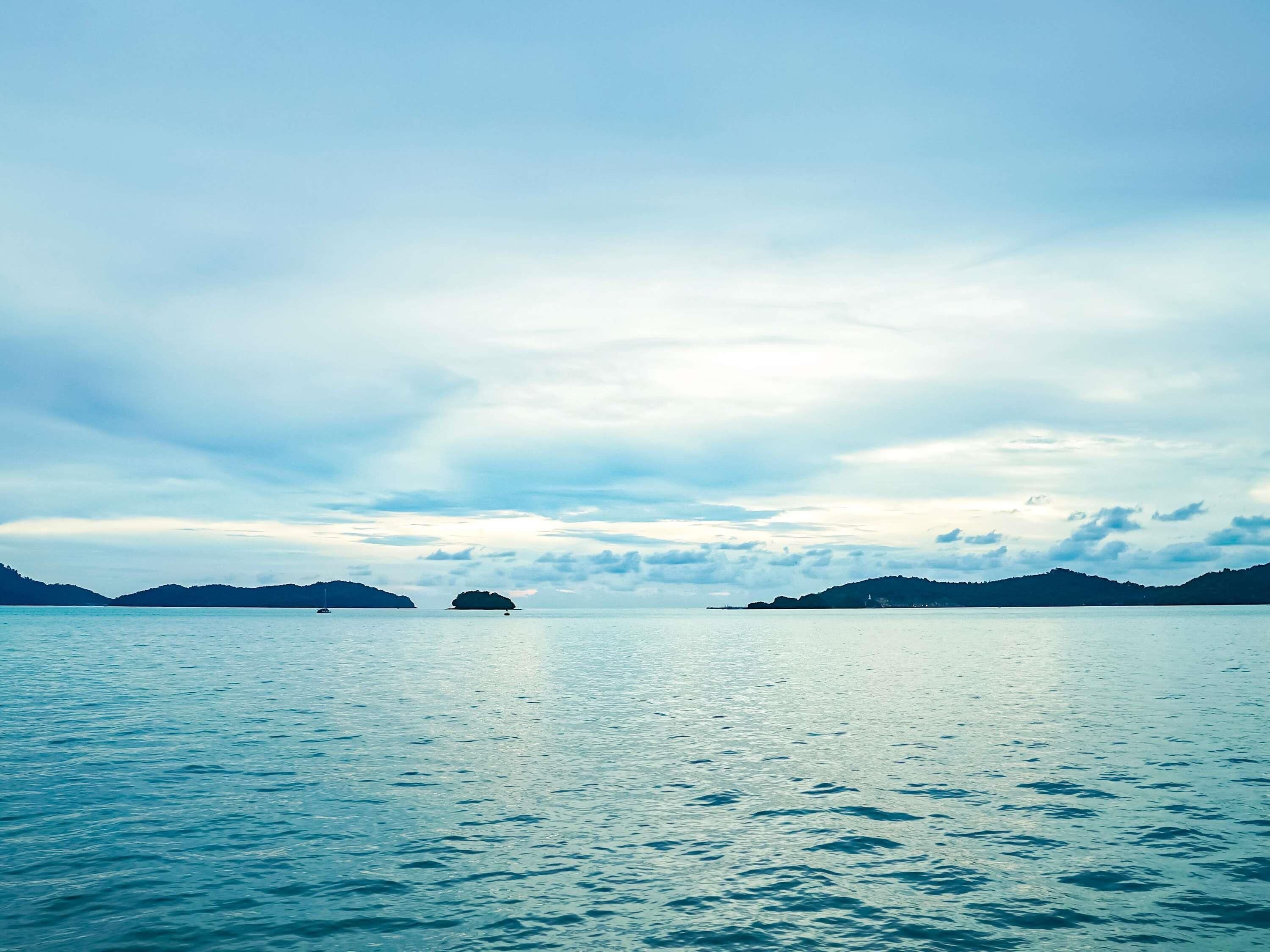 Une étendue d'eau calme, avec des reliefs visibles au loin et un ciel dégagé.