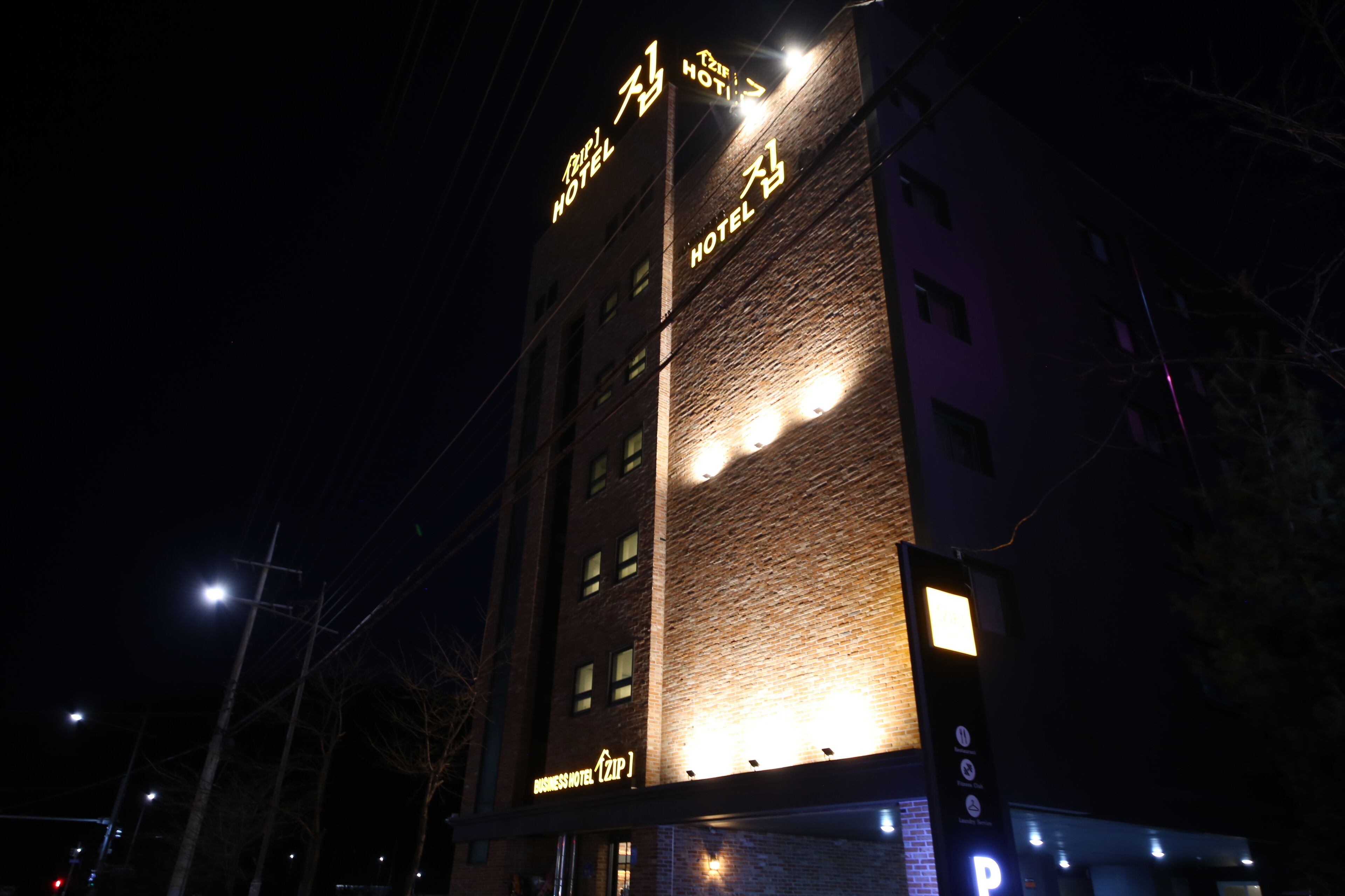A hotel building at night with illuminated signage.