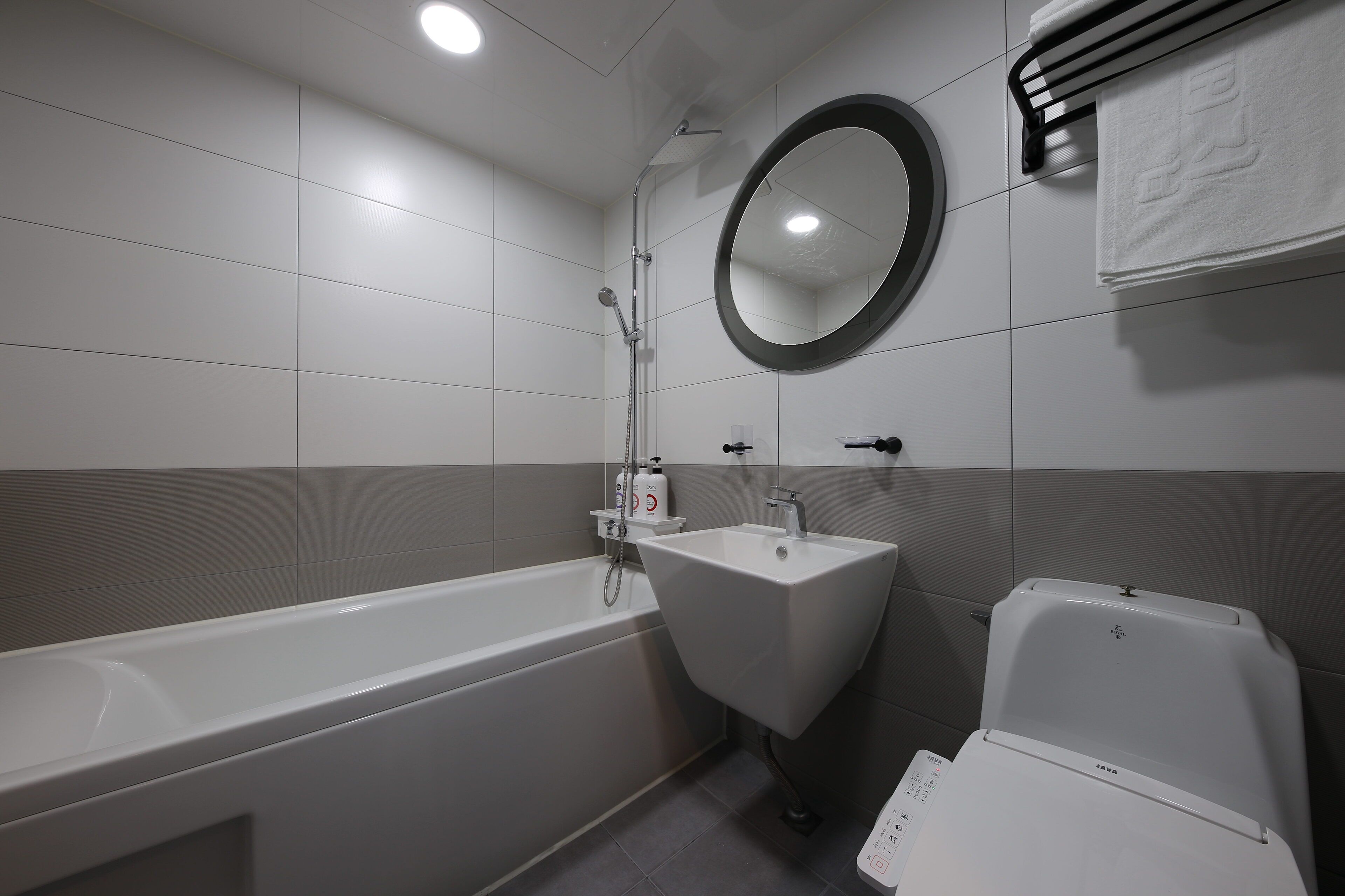 A modern bathroom with a bathtub, sink, and toilet.