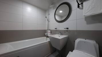 A modern bathroom with a bathtub, sink, and toilet.