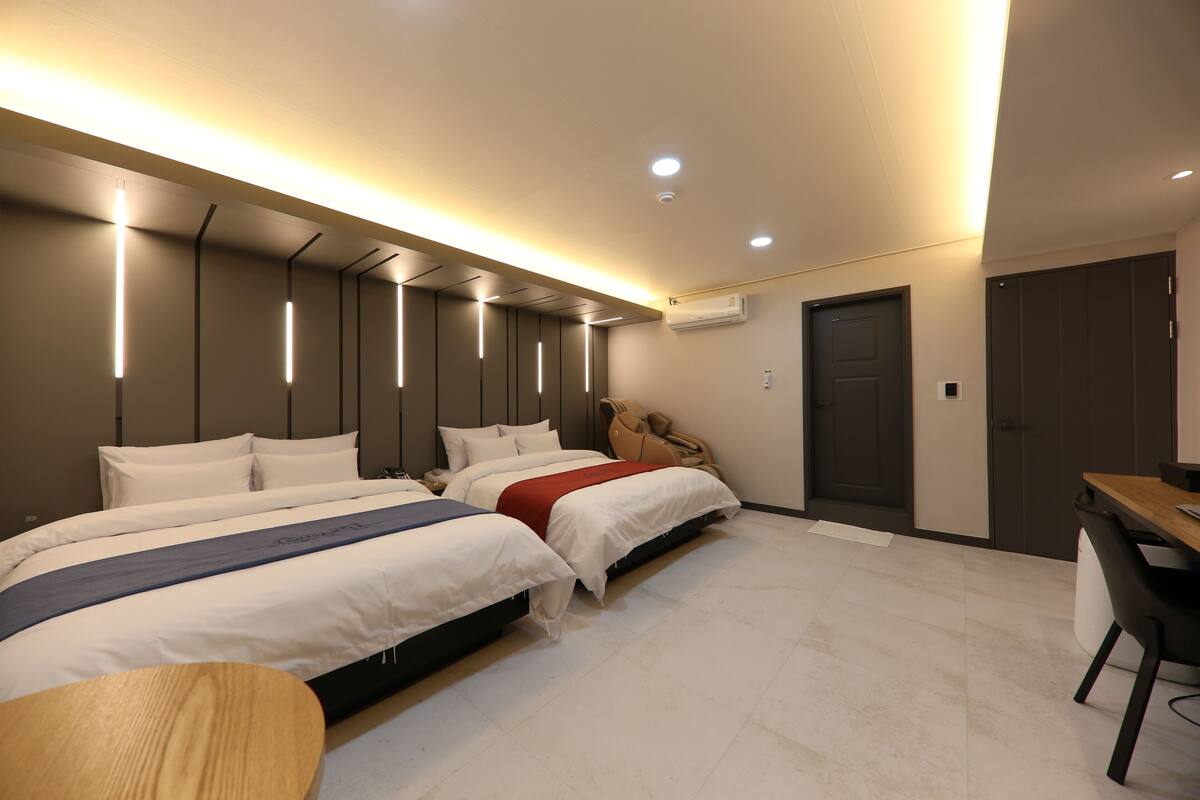 Una habitación de hotel moderna con dos camas, un escritorio y una silla.