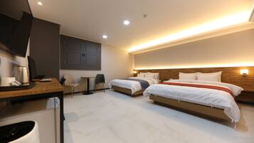 A modern hotel room with two beds, a desk, a chair, a television, and a small table.
