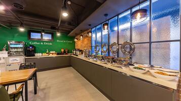 A breakfast bar with a coffee machine, cereal, and a variety of food items.