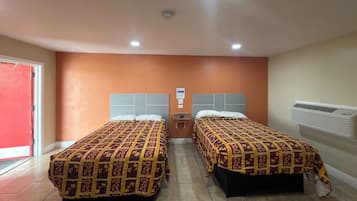 A hotel room with two beds, a red door, and an air conditioning unit.
