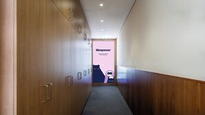 Ein Korridor mit Holzwandverkleidung und Teppichboden, der zu einer Tür mit dem Schild 'Sleepover' führt.