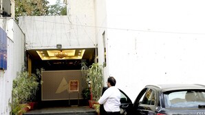 A black car parked in front of a building with a staircase leading to an entrance. - HOTEL BLUE PEARL (Bhopal)
