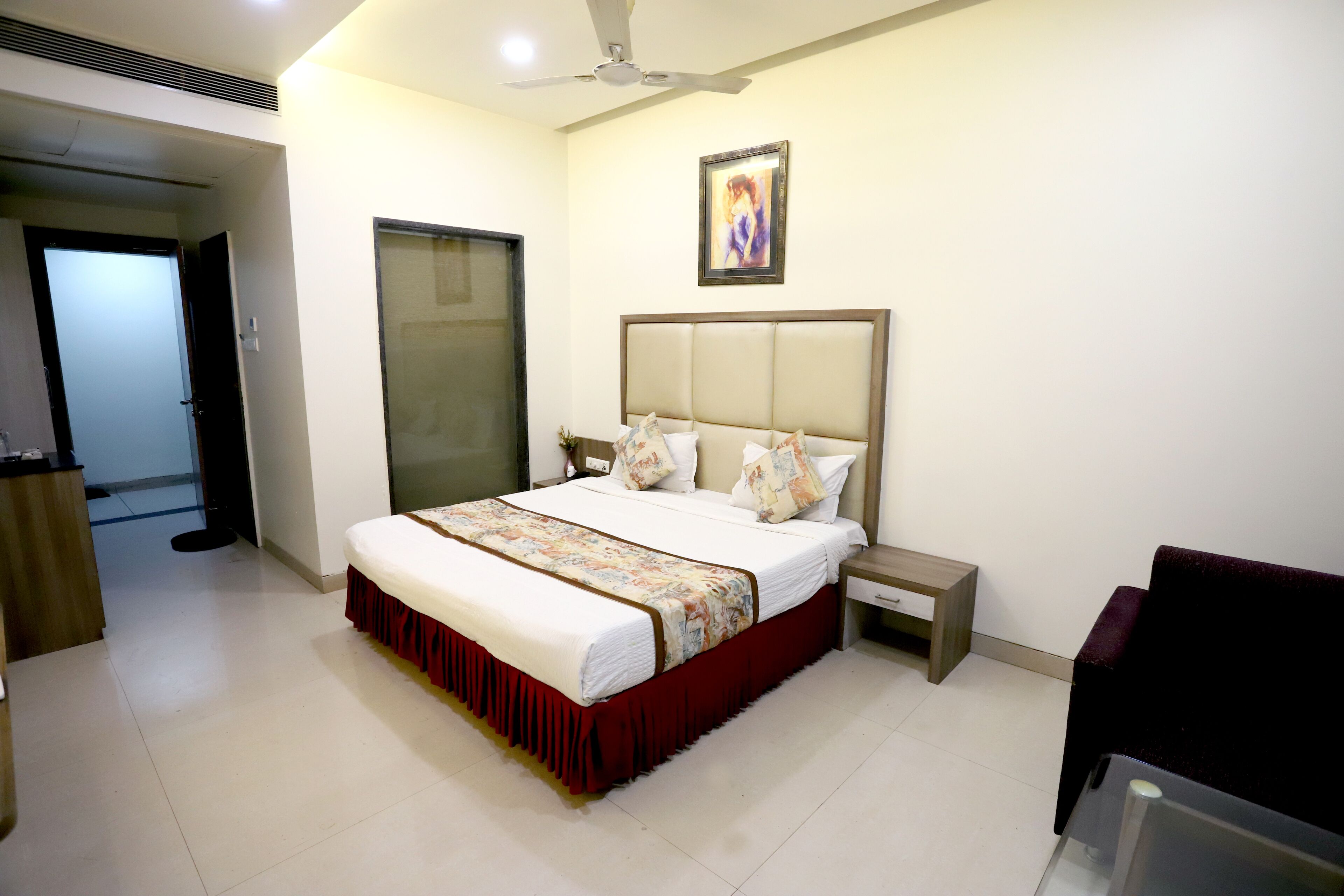 A bedroom with a bed, bedside table, and a chair.