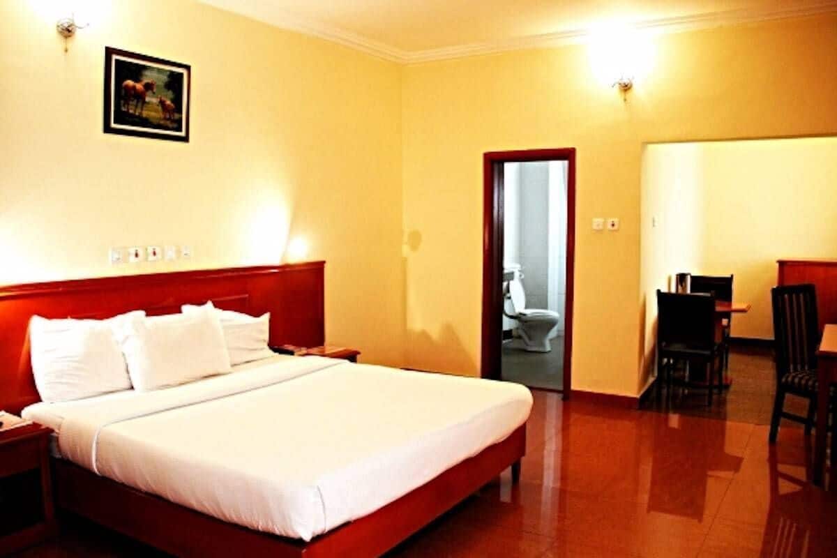A hotel room with a bed, a desk, and a chair.