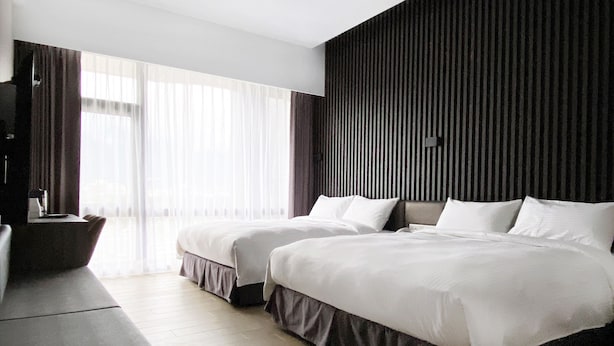 A modern hotel room with two beds, a large window with sheer curtains, and a dark textured wall. - Champ de Roses Hotel (Hualien City)