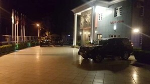 Un edificio con una entrada amplia y un estacionamiento.