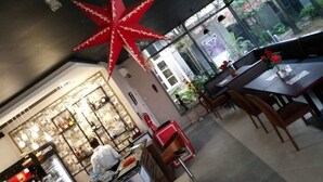 Un restaurante con una gran decoración de estrella roja, una zona de bar con la marca Guinness y un área de estar con vistas a zonas verdes exteriores.