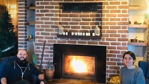 A brick fireplace with a fire, a wooden ceiling, and shelves with decorative items. - Yesil Dus Vadisi Bungalow Restoran (Kartepe)
