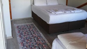 A bedroom with a bed, a bedside table, a rug, and a wooden ceiling structure. - Yesil Dus Vadisi Bungalow Restoran (Kartepe)