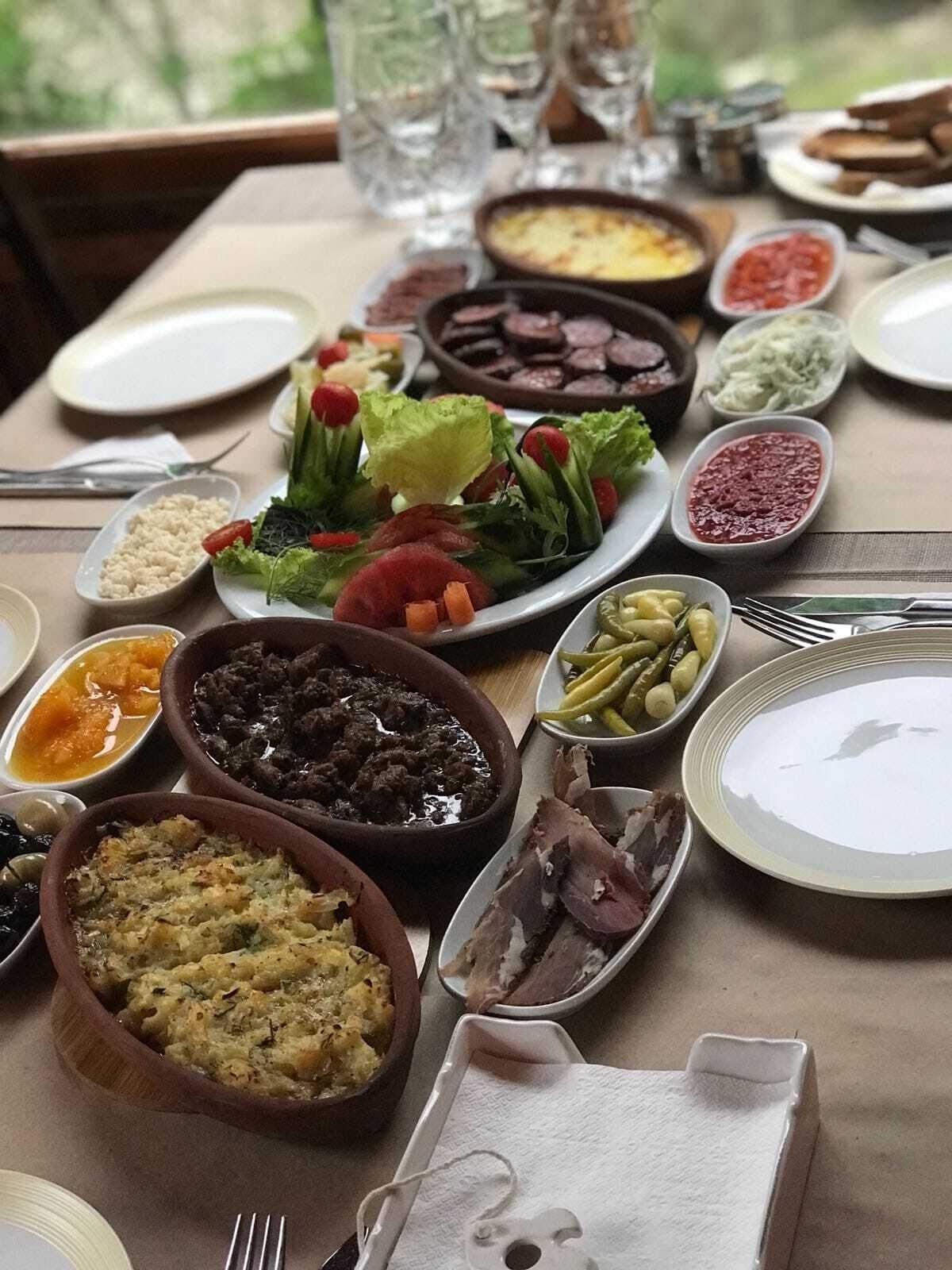 A table set with various dishes including salads, meats, and side dishes, suggesting a meal setting.