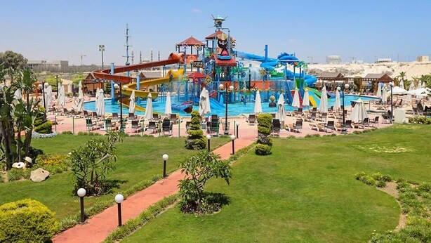 Un parque acuático con una piscina grande, toboganes y una zona de juegos.