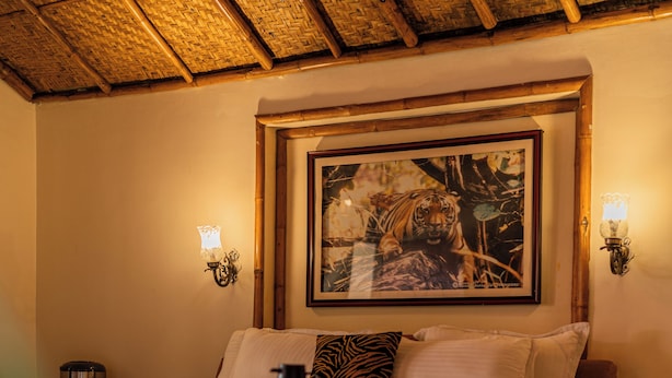 Een hotelkamer met een bed, een inlijsting foto aan de muur en twee wandlampen.