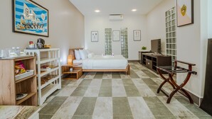 A hotel room with a bed, a desk, a bookshelf, and a television. - Calao Kep Residence Hotel (Kep)