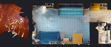 A room with a bed, a window, a sink, and a mirror.