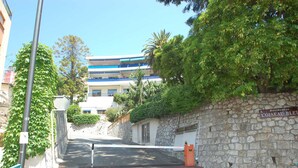 Un immeuble résidentiel avec un mur en pierre et un toit bleu.