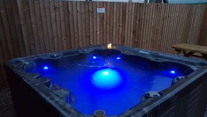 Ein Whirlpool mit einem Holzzaun im Hintergrund.