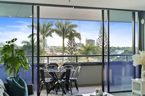 Enjoy a panoramic view of the city from the comfort of this stylish room, featuring a glass table and comfortable seating.