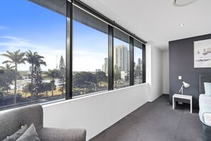 Enjoy city views from the large window, relax on the sofa, and work from the bedside table with a lamp.