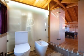 A compact bathroom with a toilet, bidet, and a shower stall.
