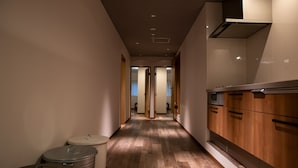 A narrow hallway with wooden flooring, a sink, and cabinets. - American Vintage Suite (Tokyo)