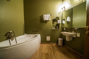 A bathroom with a bathtub, a sink, a mirror, and a trash bin. - Am Ring Hotel (Sibiu)