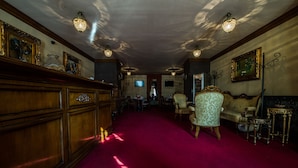 Un couloir avec un tapis rouge, des meubles en bois et des décorations murales élaborées.