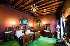 A room with a wooden ceiling, a bed with a headboard, a dresser, a mirror, and wall-mounted lamps. - Am Ring Hotel (Sibiu)