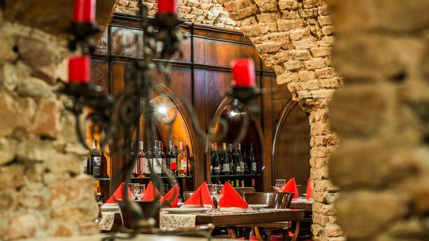 Un restaurant avec un mur en briques et un buffet en bois rempli de bouteilles.