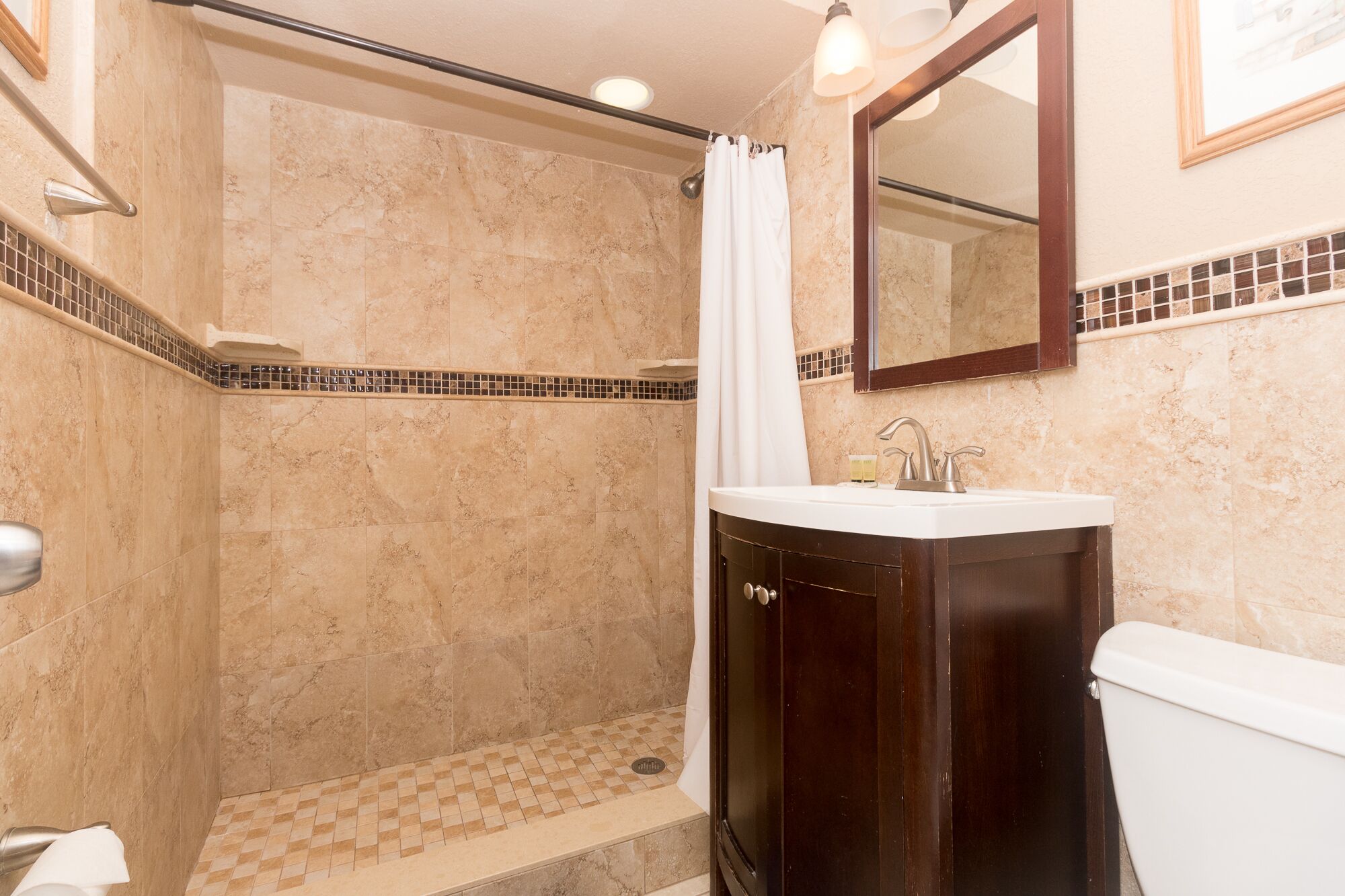A bathroom with a shower, toilet, and sink.