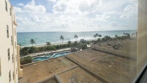 A view of a beach with a pool and palm trees. - 774 Ocean View Hollywood Beach (Hollywood)