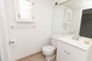 A small, clean bathroom with a toilet, sink, and mirror. - 709 Partial Ocean View Hollywood Beach (Hollywood)