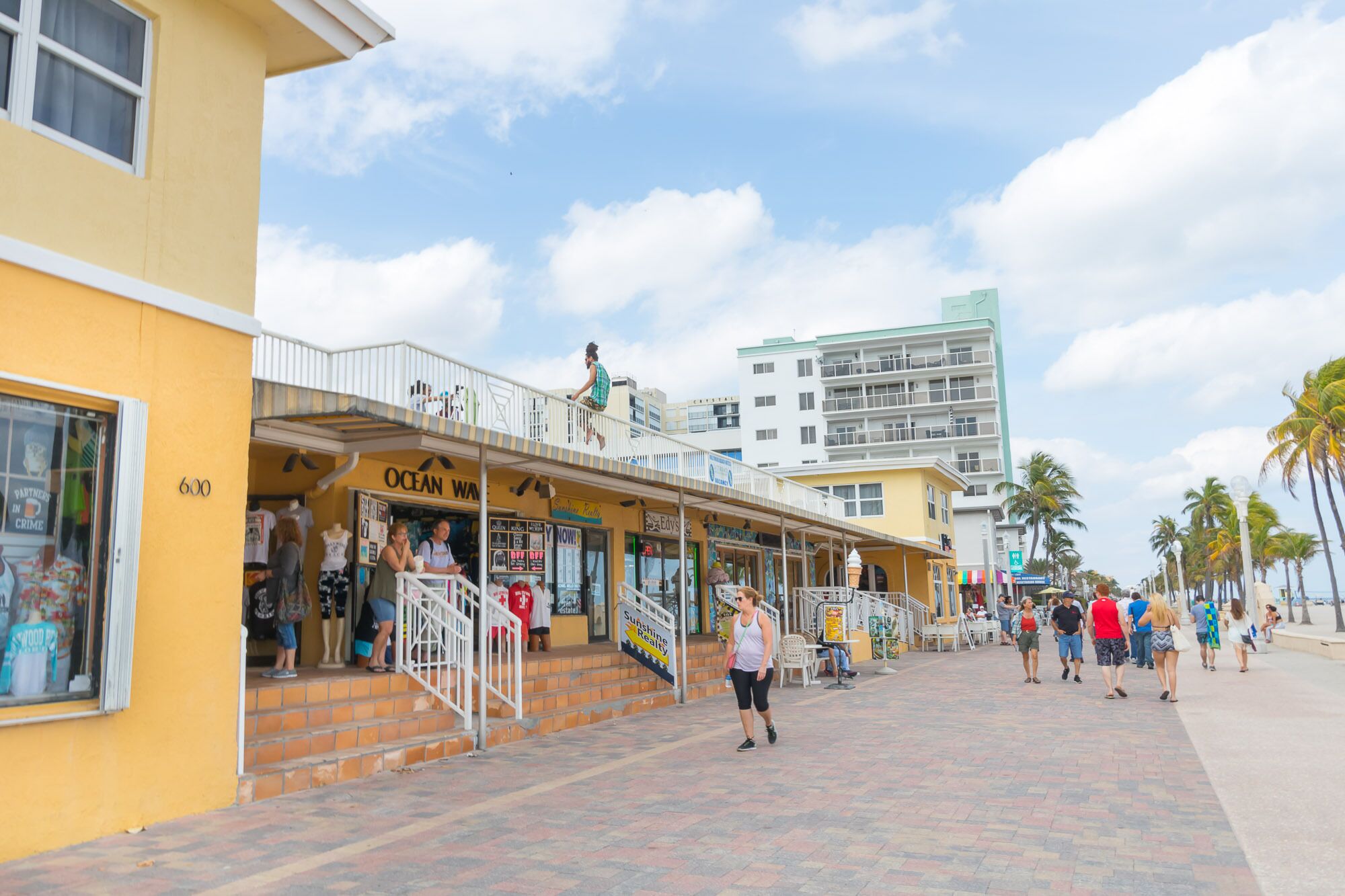 A coastal street with shops and a building with a balcony.